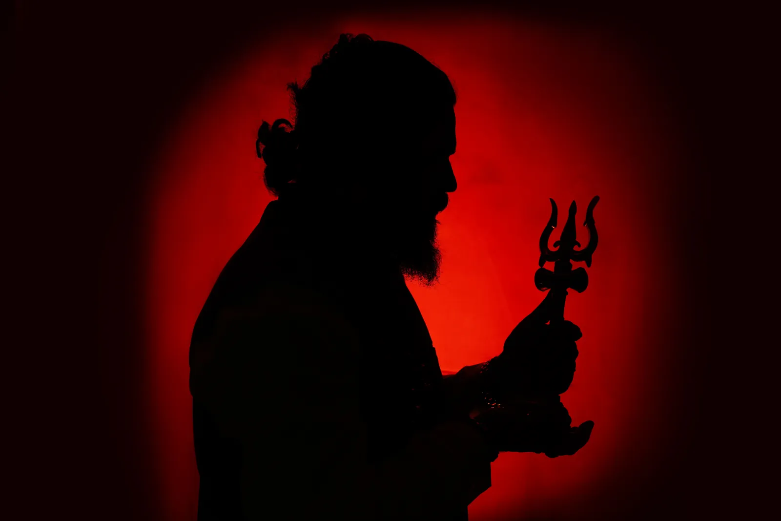 Silhouette of Arun Sharma Guruji holding a trishul